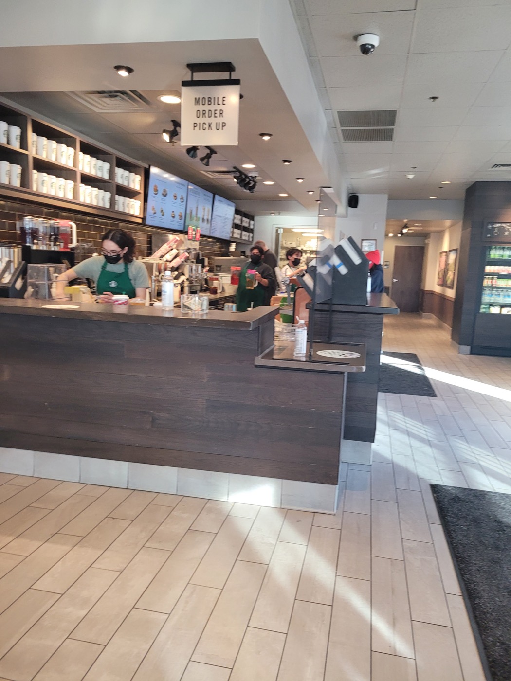 Balcão de uma loja Starbucks com uma placa escrita mobile order pickup e nenhum cliente sentado